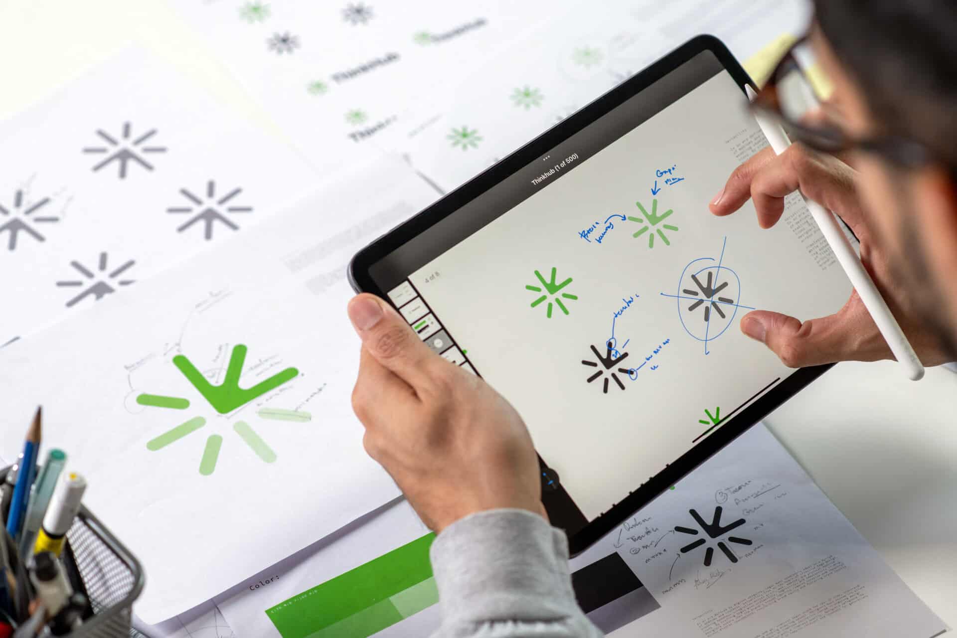 Close Up Shot Of A Graphic Designer Making Notes On Logo Designs, Using A Tablet, Designing Logos, And Showcasing The Corporate Identity And Logo Design Process.